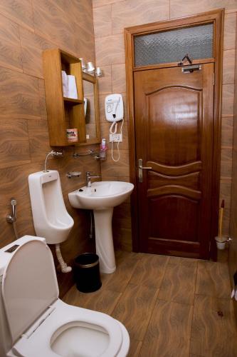 a bathroom with a toilet and a sink and a door at Velvet Suites in Kigali