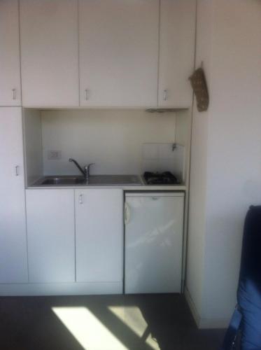 Una cocina con gabinetes blancos y un fregadero. en Firenze in collina con piscina, en Bagno a Ripoli