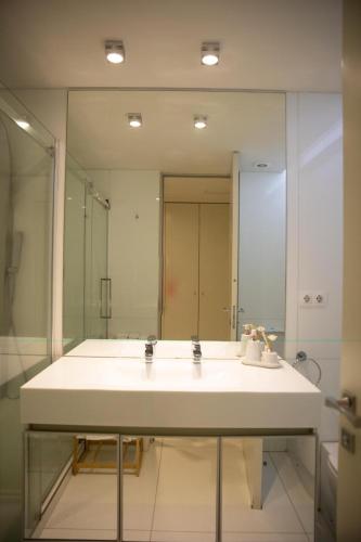 een badkamer met een wastafel en een grote spiegel bij Elegant 2- bedroom in heart of Talatona in Belas