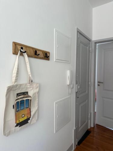 a bag is hanging on a wall next to a door at Nassima Lisboa in Lisbon
