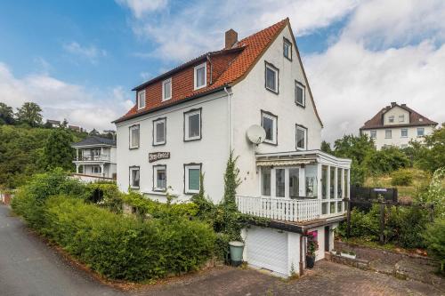 a white house with a red roof at Ferienwohnung Schloss-See-Bergblick in Waldeck