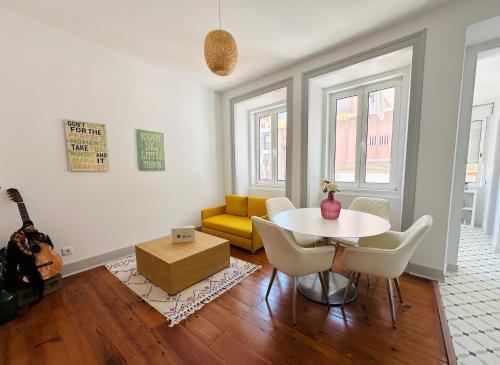 a living room with a table and a yellow couch at Nassima Lisboa in Lisbon