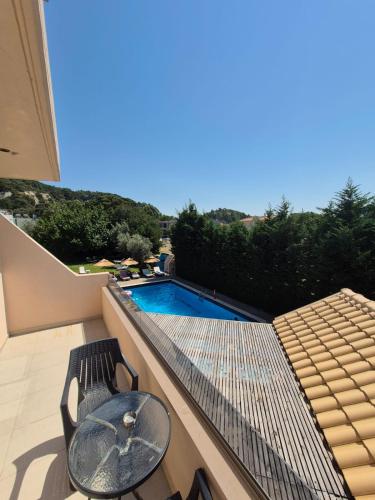 a balcony with a table and chairs and a swimming pool at Maritina Apartments in Ixia