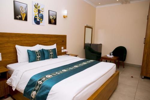 a bedroom with a large white bed with blue pillows at Velvet Suites in Kigali