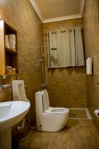 a bathroom with a toilet and a sink at Velvet Suites in Kigali
