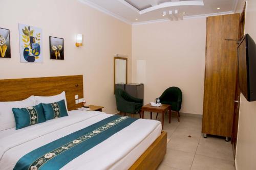 a hotel room with a bed and a tv at Velvet Suites in Kigali