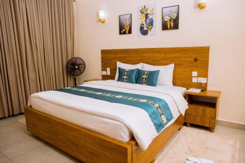 a bedroom with a large bed with a wooden headboard at Velvet Suites in Kigali