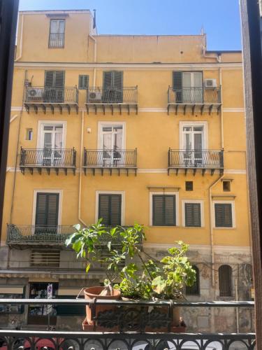 Un edificio amarillo con balcones y una ventana. en La Bella Balla-rò Rooms, en Palermo