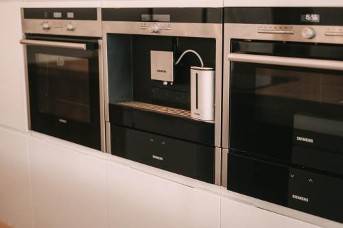 deux micro-ondes dans une cuisine avec un appareil électroménager dans l'établissement Grand appartement Haussmannien 160m2, à Besançon