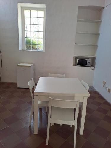 a white table and chairs in a room with a window at DIMORA storica NONNA ELVIRA in Casarano