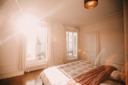 une chambre avec un lit et une fenêtre dans l'établissement Grand appartement Haussmannien 160m2, à Besançon