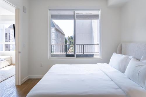 a white bedroom with a bed and a window at Luxury 2 Bedroom 2 Bathroom Residence With Fitness and Outdoor Pool in Los Angeles
