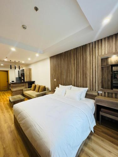 a bedroom with a large white bed and a living room at TMS Quy Nhơn - Hupa Apartment View Biển in Quy Nhon