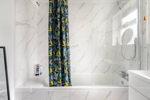 a bathroom with a shower curtain and a tub at The Barack Nest Colchester in Colchester