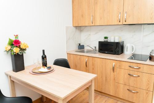 a small kitchen with a table and a microwave at Apartamenty Cicha - bezpłatny parking in Krynica Zdrój