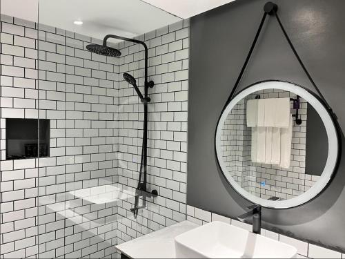 un bagno con lavandino e specchio di PROXY Plus Pangasinan a Alaminos