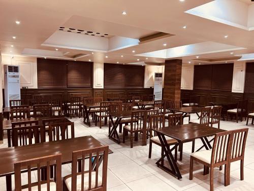 a dining room with wooden tables and chairs at Hotel Majestic, Uchgaon NH4 in Kolhapur