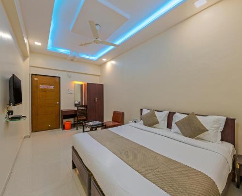 1 dormitorio con 1 cama grande y techo azul en Hotel Anand Inn Residency Solapur, en Solapur