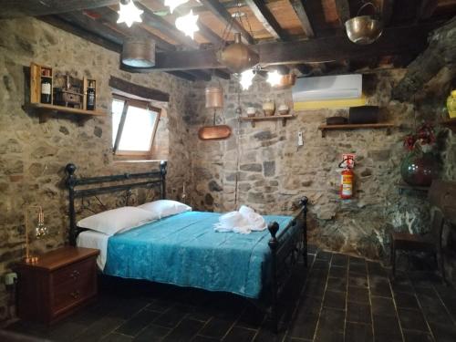 a bedroom with a bed in a stone wall at Da Castruccio degli Antelminelli in Coreglia Antelminelli
