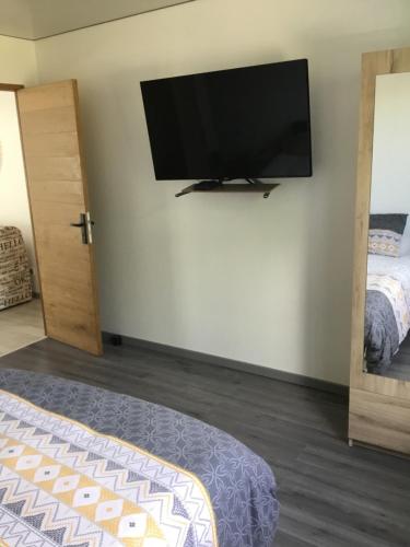 a bedroom with a flat screen tv on the wall at Bienvenue dans notre maison in Saint-Georges-dʼOléron