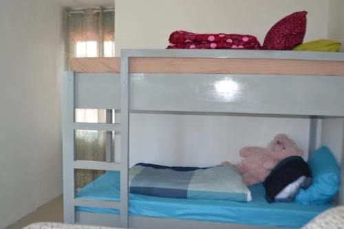 a bunk bed with a teddy bear on the bottom bunk at HTL Apartment in Aglalana