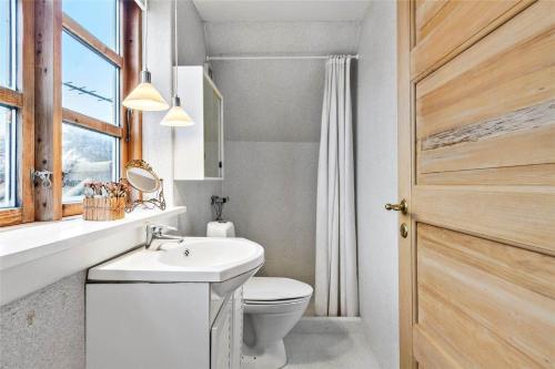 a bathroom with a toilet and a sink and a window at 8004-Kalvehave-Kalvehave-Havnevej-39-1-sal in Kalvehave