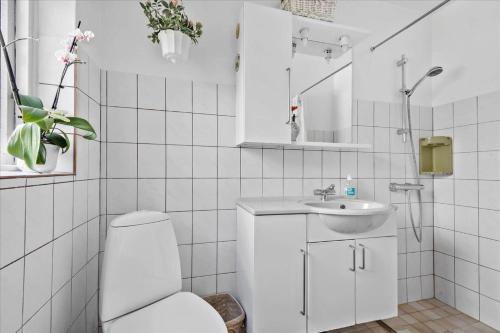 a white bathroom with a toilet and a sink at R608-Rodvig-Klintevej-32 in Rødvig