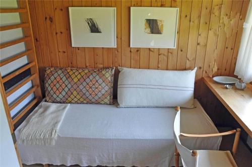スタイにある1078-Stege-Kristtjornvej-33の壁に2枚の絵が飾られた小屋のベッド