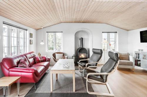 a living room with a red leather couch and a fireplace at 8207-Vordingborg-Strandparken-22 in Vordingborg