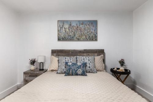 a bedroom with a bed with a painting above it at UF Apartment on Archer Road Near Shands & VA ! in Gainesville