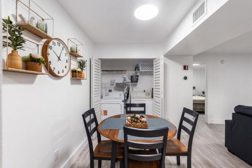 a dining room with a table and chairs and a clock at UF Apartment on Archer Road Near Shands & VA ! in Gainesville