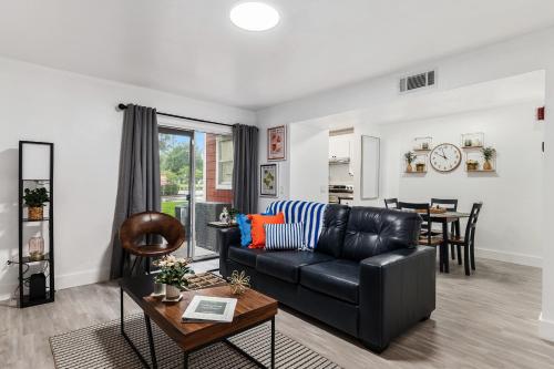 a living room with a black leather couch and a table at UF Apartment on Archer Road Near Shands & VA ! in Gainesville