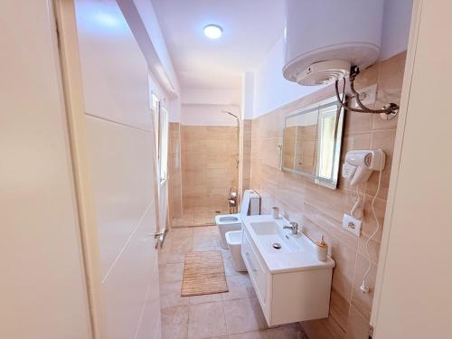 La salle de bains est pourvue d'un lavabo et de 2 toilettes. dans l'établissement Kraja Home, à Shkodër