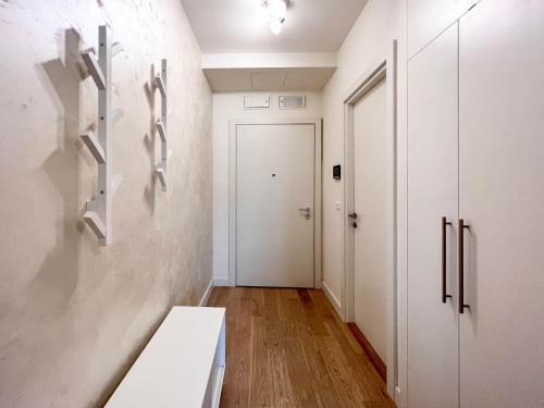 un couloir avec une porte blanche et un banc blanc dans l'établissement BW City Elegance Collection, à Belgrade
