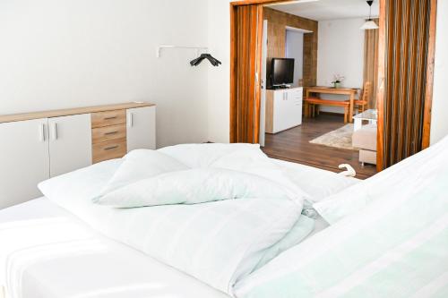 a bedroom with a bed with white sheets at Apartman Nina in Jajce