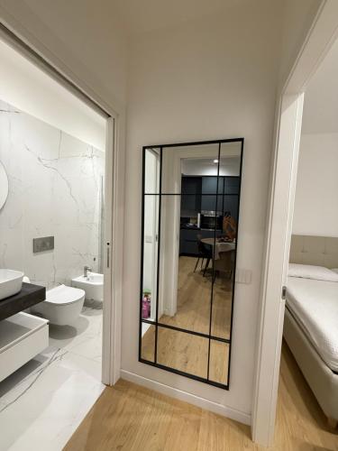 een badkamer met een spiegel, een bed en een wastafel bij Diletta Luxury Apartment in Senigallia