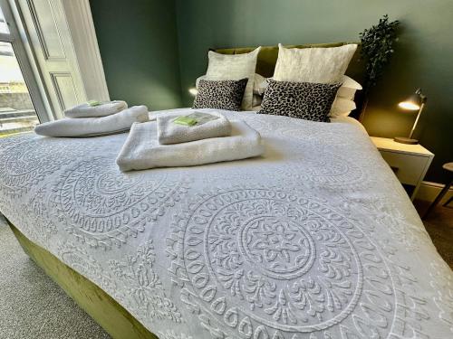 two towels on a white bed in a bedroom at Eden on the Hoe in Plymouth