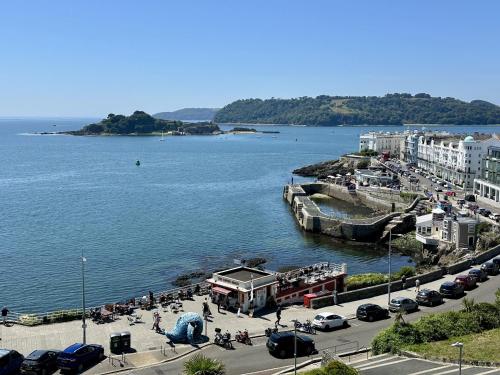 a large body of water with cars parked next to a pier at Eden on the Hoe in Plymouth