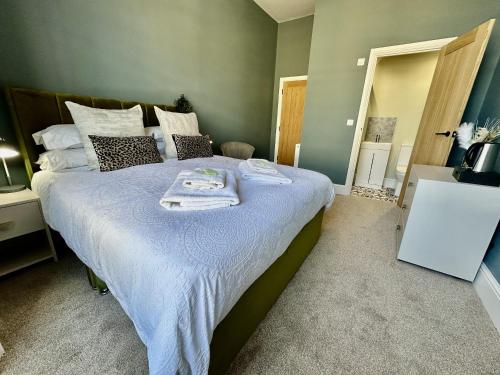 a bedroom with a large bed with towels on it at Eden on the Hoe in Plymouth