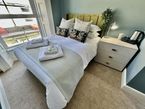 Eden on the Hoe في بلايموث: سرير عليه منشفتين في غرفة النوم
