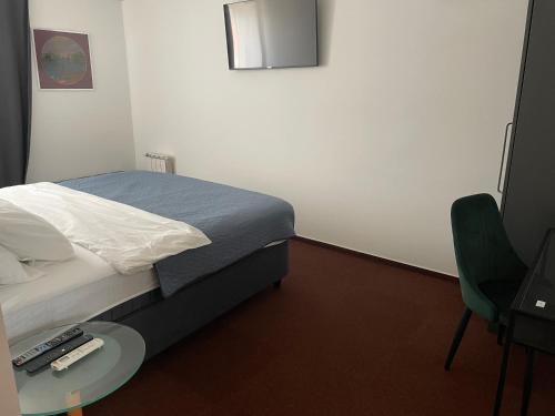 a bedroom with a bed and a table and a chair at hotel Diana in Murska Sobota