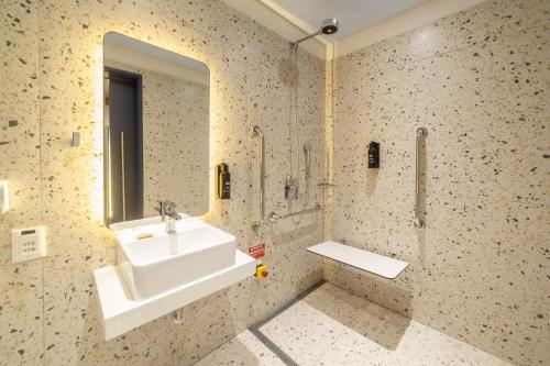 a bathroom with a sink and a mirror at ibis Styles Fortaleza Shopping Giga Mall in Fortaleza