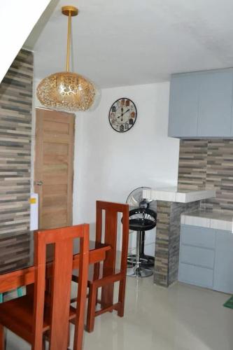 a kitchen with a table and chairs and a clock on the wall at HTL Apartment in Aglalana