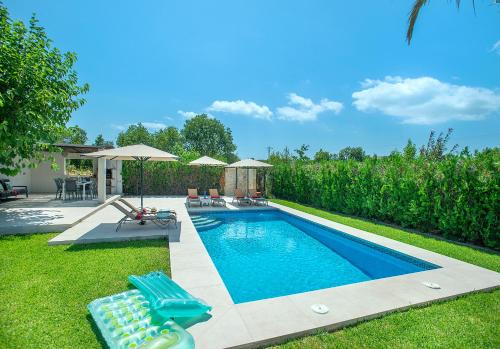 ein Swimmingpool mit zwei Stühlen und einem Sonnenschirm in der Unterkunft Owl Booking Villa Divina - Luxury Retreat in Pollença