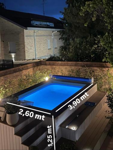 a small swimming pool in a backyard at night at Casa Matilde piano terra 100mq con parking e piscina in Ferrara