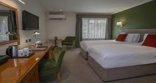 a hotel room with two beds and a television at Best Western Hotel de Havelet in St Peter Port
