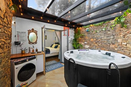 a bathroom with a large tub in a stone wall at The Wollemi Smart Palace in Katoomba