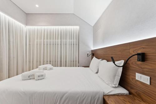 Un dormitorio con una cama con dos toallas blancas encima. en GuestReady - Stylish base steps from attractions, en Oporto