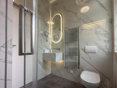 a bathroom with a toilet and a sink and a mirror at Hotel Central in Pécs