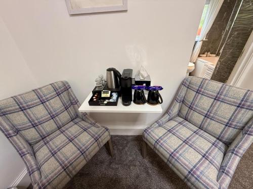 two chairs sitting next to a table with shoes on it at Carron Cottage in Inverness